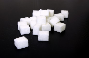 White sugar cubes on black background, Sugar prices globally, unhealthy lifestyle 