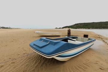 Two pleasure boats anchored on a river bed