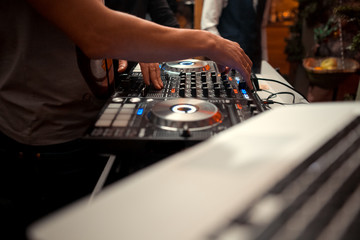 DJ console cd mp4 deejay mixing desk Ibiza house music party in nightclub with colored disco lights.