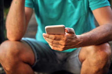 Modern man using cellphone outdoors.