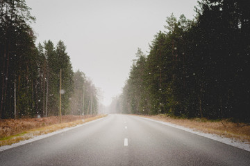 Snow falling on an empty winter road 