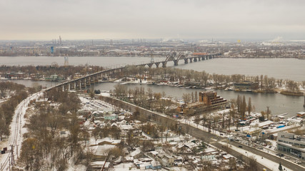 Aerial top view from drone on railway bridge above Dnieper river in Dnipro city. Winter landscape and cityscape background. (Dnepr, Dnepropetrovsk, Dnipropetrovsk)