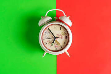 white retro alarm clock idolated on colorful background on wood surface b