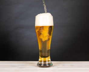 Pour beer in a glass with black background