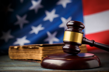 Wooden hammer and ancient book on the American flag background