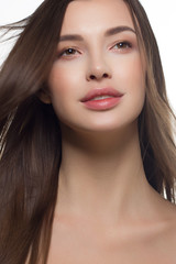 Obraz premium Close-up of beauty girl with long straight developing hair and radiant daytime makeup on her face. Skin care natural cosmetics in the spa salon or cosmetology.