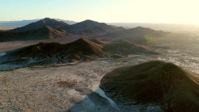Aerial Forward: Vast Mountains of the Desert with the Sun Shining Above