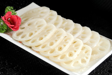 Fresh lotus root slices in a white dish