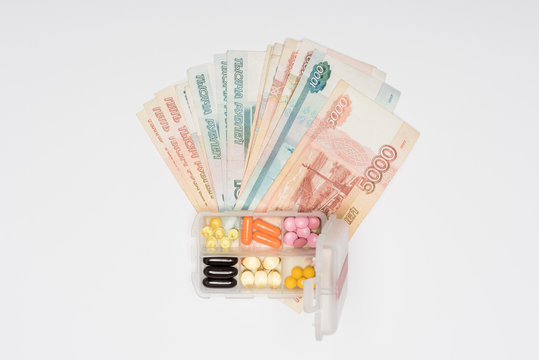 top view of cash and plastic box with pills isolated on grey