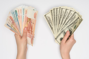 cropped view of woman holding russian rubles and dollars in hands isolated on grey