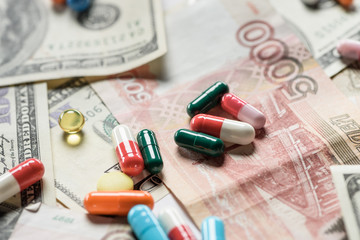 close up of bright different pills on money background