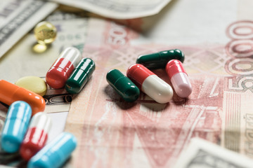 selective focus of different pills on money background