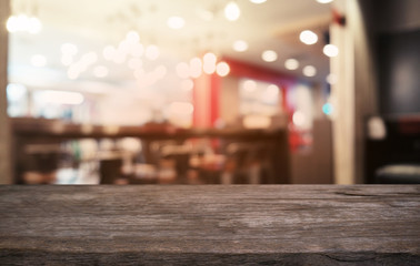 Empty dark wooden table in front of abstract blurred bokeh background of restaurant . can be used for display or montage your products.Mock up for space.