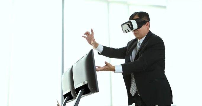 Asian middle-aged businessmen are viewing the contents of the virtual reality device, which is a technology of the future, Helps to make business easier and more successful and moving his hands.