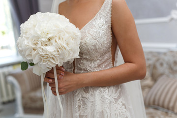 the bride holds a wedding bouquet of white flowers indoor
young girl in a white dress with a delicate bouquet
wedding bouquet of white flowers
