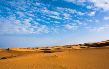 Fototapeta na wymiar Paisaje de desierto con cielo nublado, tono azul y arena, espacio libre