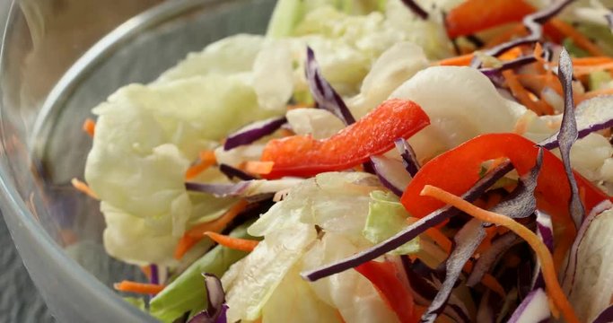 Healthy eating. Bowl of salad mix with vegetables and greens on wooden table close-up.