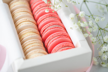 Coral and beige cakes macarons or macaroons in a white gift box. The concept of Valentines day and spring's celebrating.