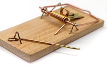 Wooden home mousetrap on a white background. Selective focus. Closeup of an unloaded mouse trap....
