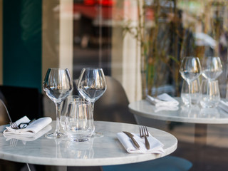 Table setting in a French restaurant for two. View through a window from a street.