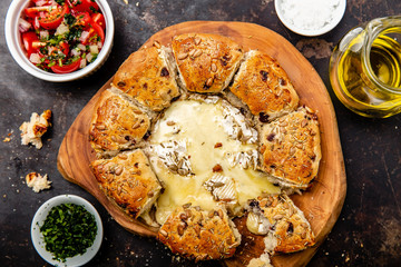 Camembert baked in the oven with herb bread served with tomato salad