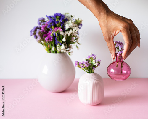 Hand fixing a vase of sea lavender flowers