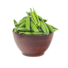 green peas in pods.  in a clay plate on a white background