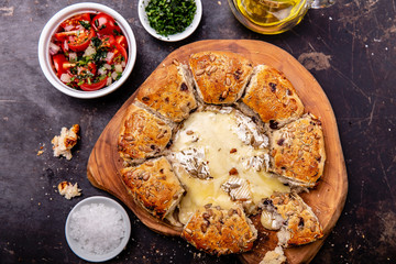 Camembert baked in the oven with herb bread served with tomato salad