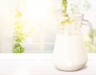 Glass jug of fresh milk isolated on white