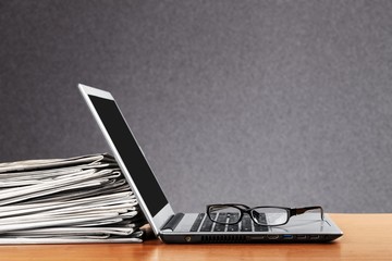 Laptop and black glasses  on   background.