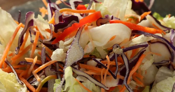 Healthy eating. Bowl of salad mix with vegetables and greens on wooden table close-up.