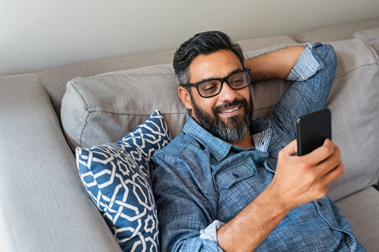Man using smartphone at home