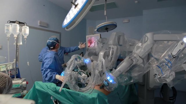 Doctors using surgery robot in surgical room in hospital with robotic technology equipment, machine arm surgeon in futuristic operation room. Medical robot surgery 3D view