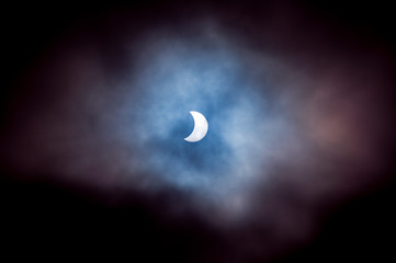 A partial solar eclipse through the cloud with blue purple haze from Edinburgh, Scotland, UK in 2015