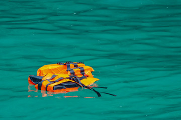Empty life jacket floating on sea water. lost human or ominous concept.