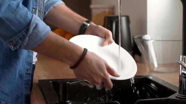 Man's hands washing dishes in the kitchen