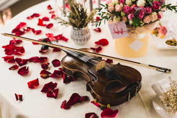 Romantic valentine table setting with wine, dishes, beautiful flowers in box, empty glasses, rose...
