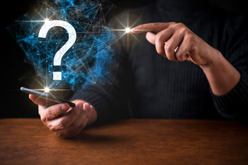 close up business man with smartphone with question mark hologram show up on black background