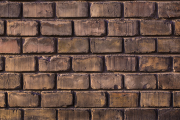 Wall made from red and sometimes colorful bricks of regular shapes and random distribution slotting together precisely. Close up architecture photography. Creative wallpaper photography.