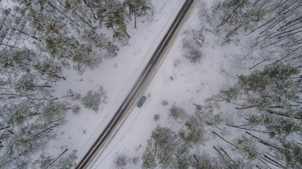 Aiereal wives of the road in winter forest with lot of trees and snow , drone shoot ,Ukraine 