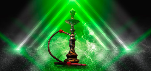 Hookah smoking on the background of an empty scene with a concrete floor, neon lights and smoke....