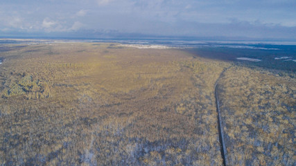 Aiereal wives of the road in winter forest with lot of trees and snow , drone shoot ,Ukraine 