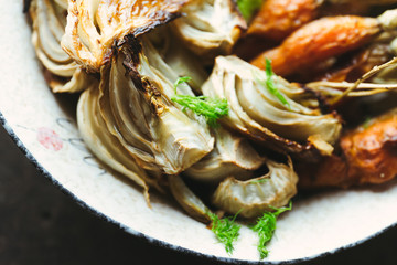 Close up. Roasted fennel and baby carrots on tray. Rustic background. - obrazy, fototapety, plakaty
