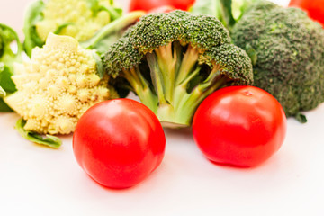 Ripe vegetables tomatoes romanesco broccoli on white wooden background with copy space for your text