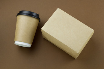 top view disposable paper cup with plastic lid and cardboard box mock up on brown background