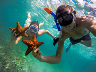 Naklejka premium couple snorkeling with starfish 