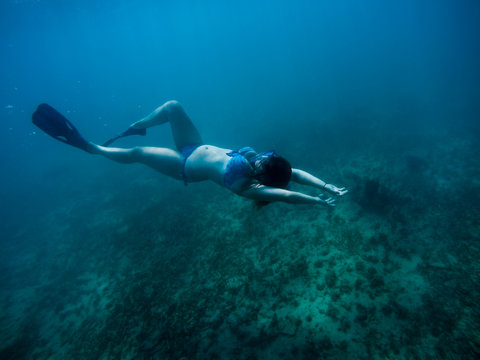 Girl Freediving In Deep Blue