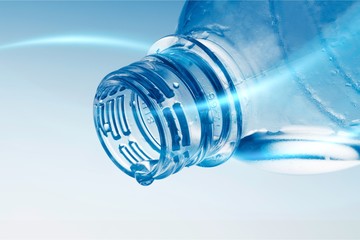 Water Drop Pouring out of Plastic Bottle on the Blue Background