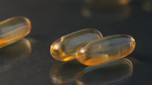 Close up of oil filled capsule soft gel suitable for presenting food supplements: fish oil, omega 3, omega 6, omega 9, vitamin A, vitamin D, vitamin D3, vitamin E, evening primrose oil, borage oil