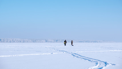 Fototapeta na wymiar A lone fisherman on a frozen lake. Ice fishing.